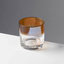 Load image into Gallery viewer, The Aristocrat cocktail glass with transparent amber / orange color stripe against a contrasting gray background.