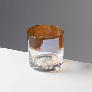 The Aristocrat cocktail glass with transparent amber / orange color stripe against a contrasting gray background.