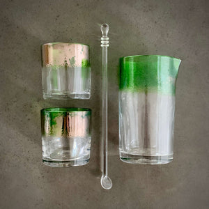 The Naturalist Cocktail Set - Alined in a grid, one mixing glass, one spoon, and two rocks glasses, all with a bright emerald green band of color.