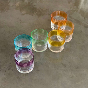 Set of 6 cocktail glasses in a striped ROYGBV rainbow color pattern, lined up in an S curve.