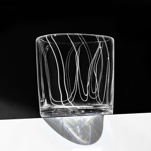 Simpatico in White rocks glass with vertical fine white lines against a dramatic black background.